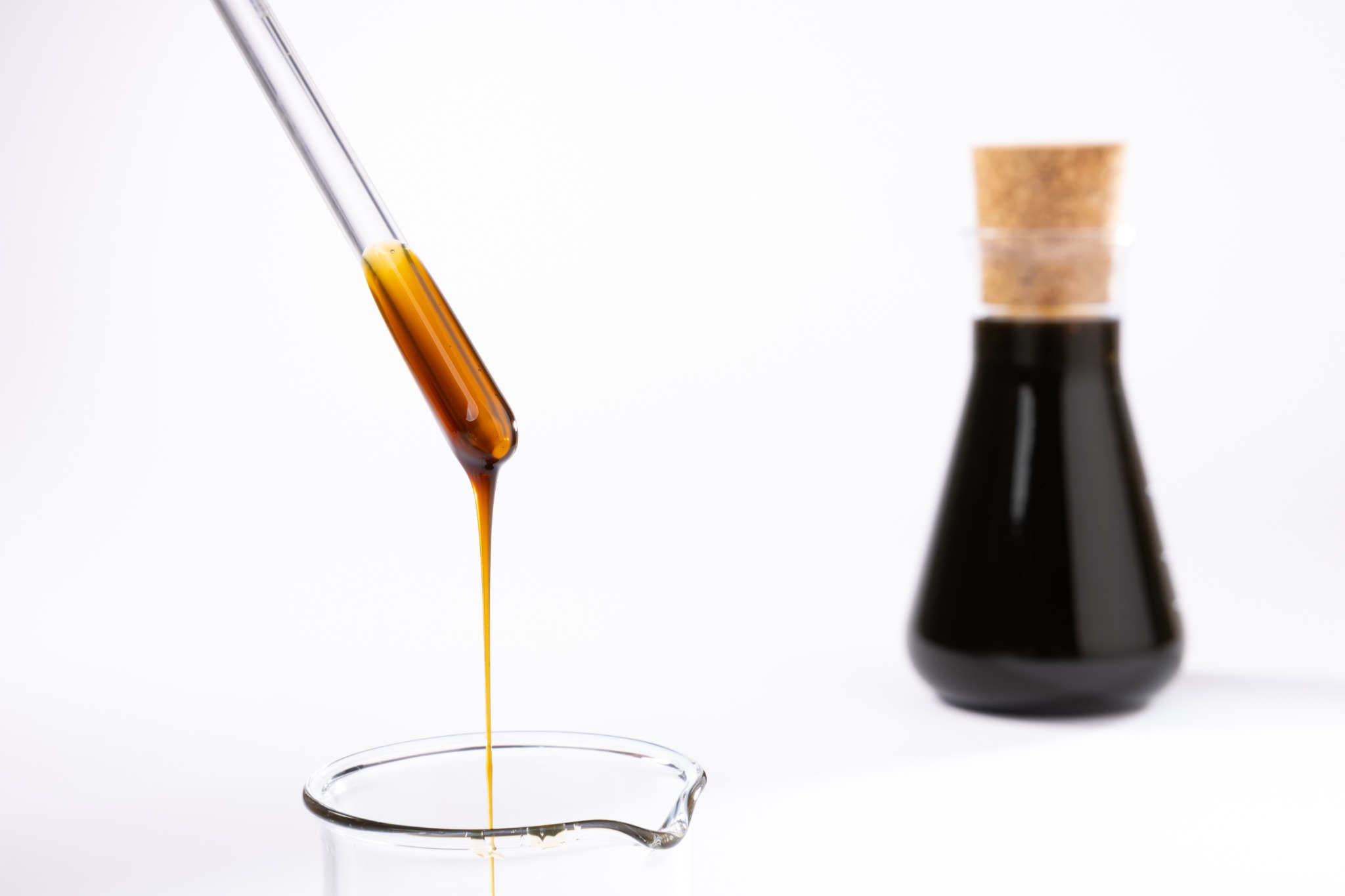Crude sunflower lecithin sample with laboratory flask in background